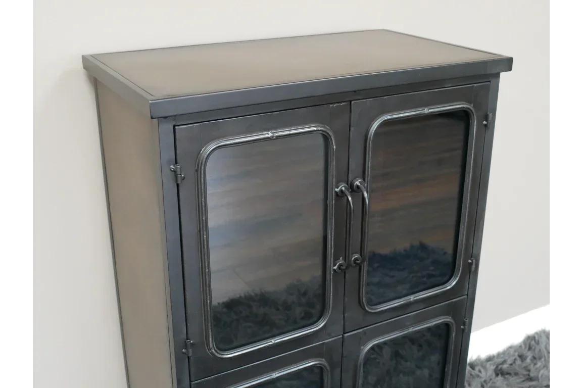 Black metal storage cabinet with glass doors and double handles against light wall