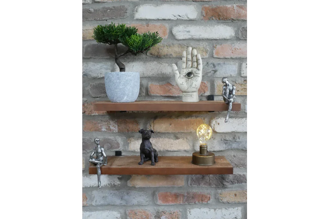 Decorative wall shelves with figurines, potted plant, ceramic hand and vintage table lamp