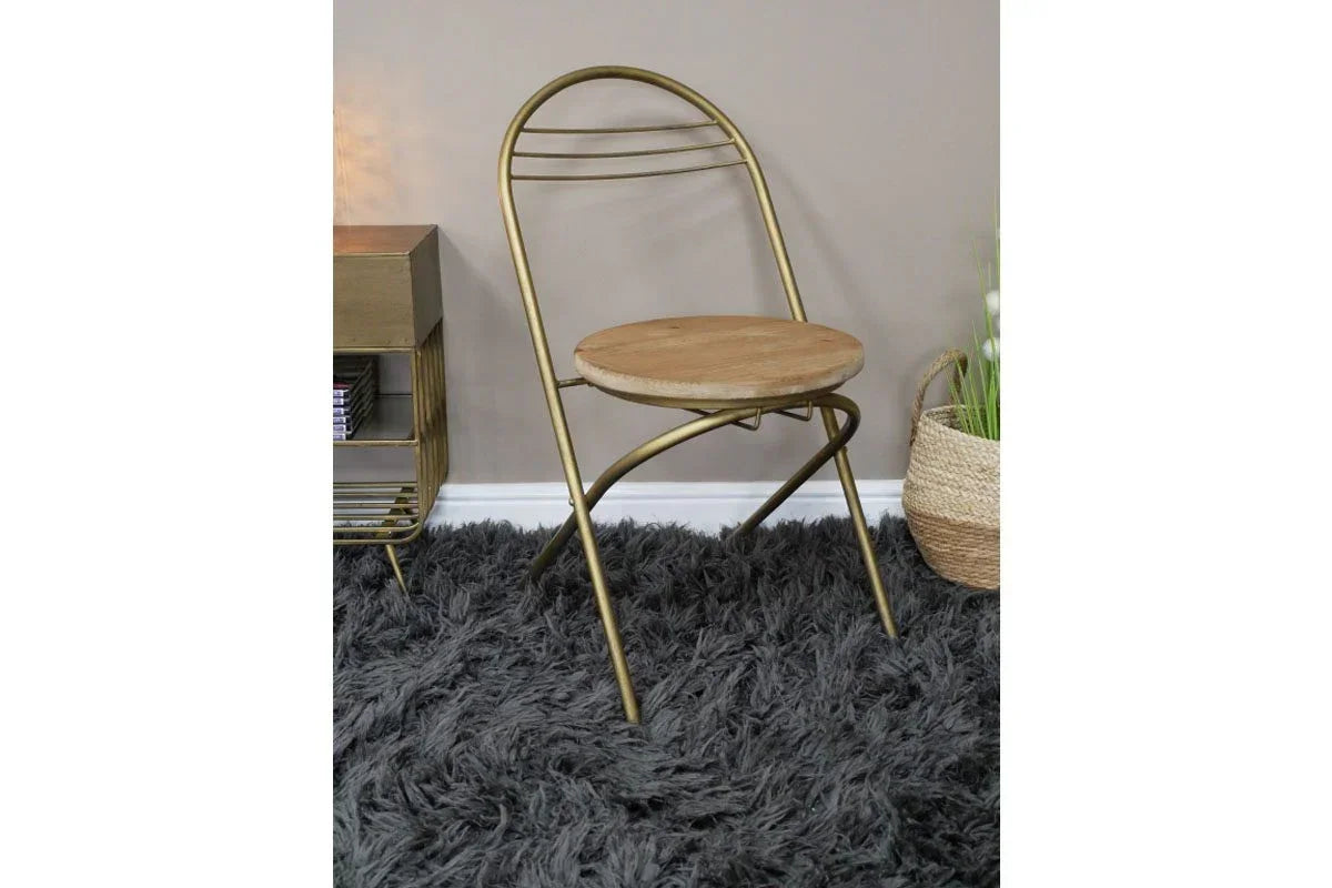 Gold metal and wood dining chair with round seat on grey shaggy rug