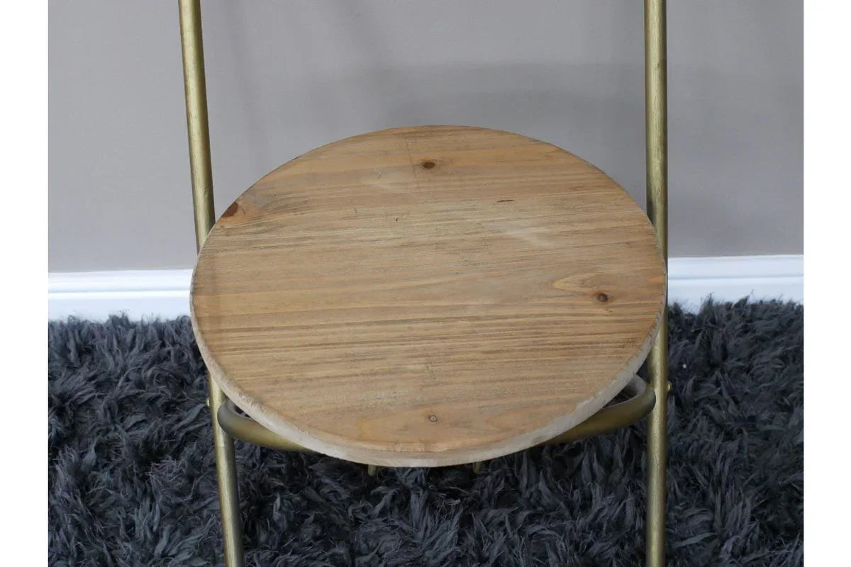 Round wooden stool seat with gold metal legs on dark grey shaggy rug
