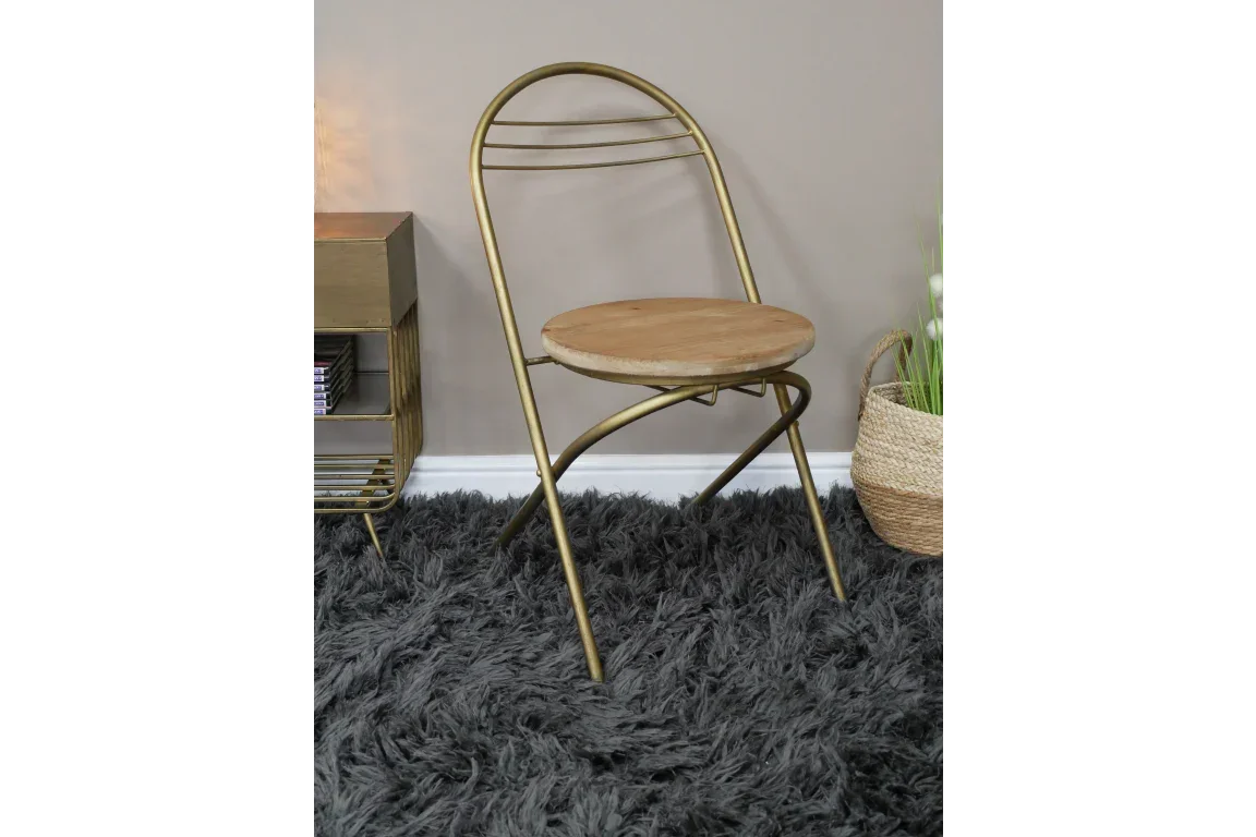 Gold metal frame dining chair with round wooden seat on grey shaggy rug