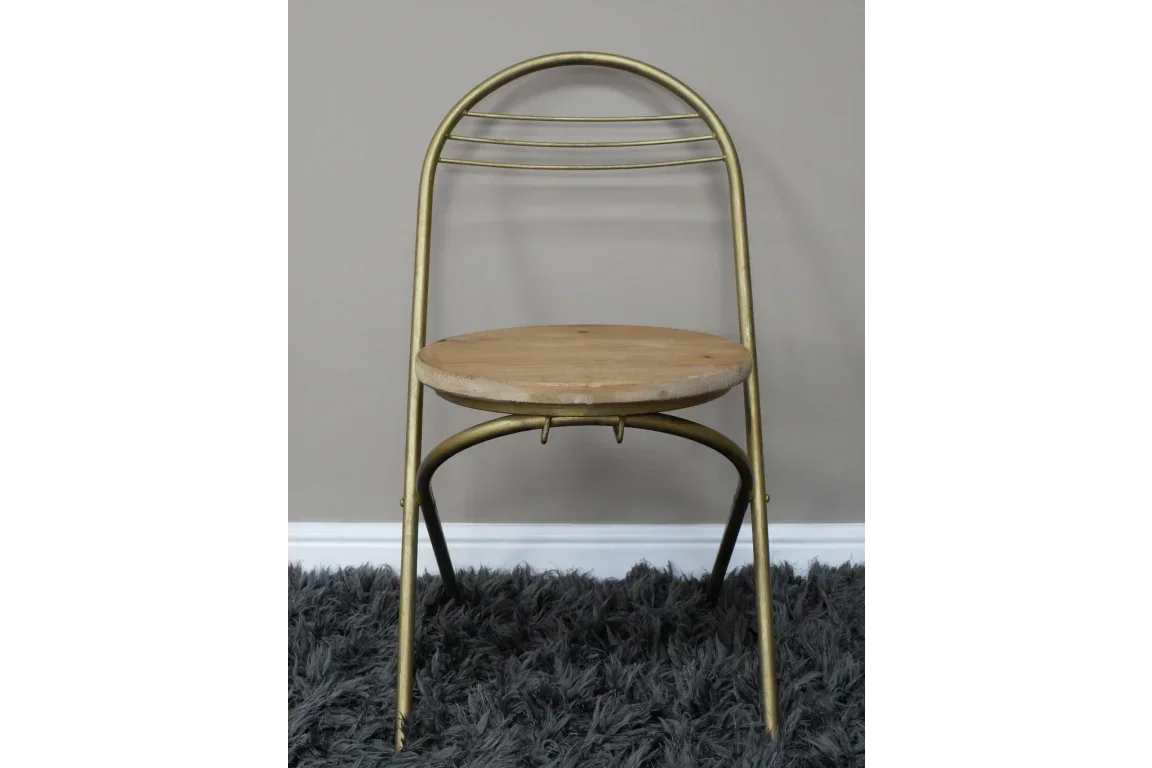 Gold metal dining chair with curved backrest and round wooden seat on grey rug