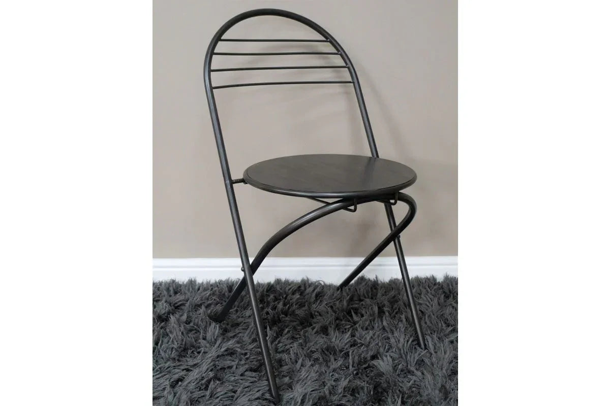 Black metal folding chair with round seat on gray shaggy rug