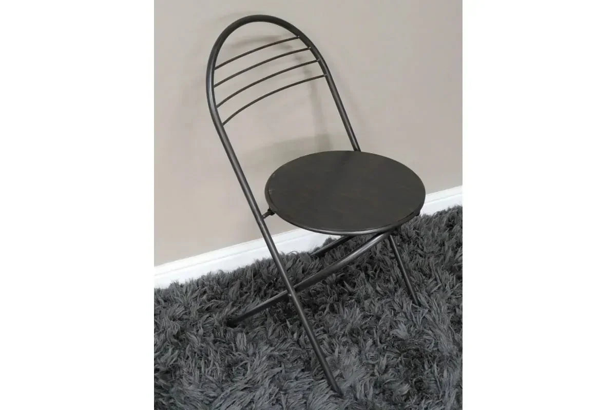 Black metal folding chair with round seat on grey shaggy rug
