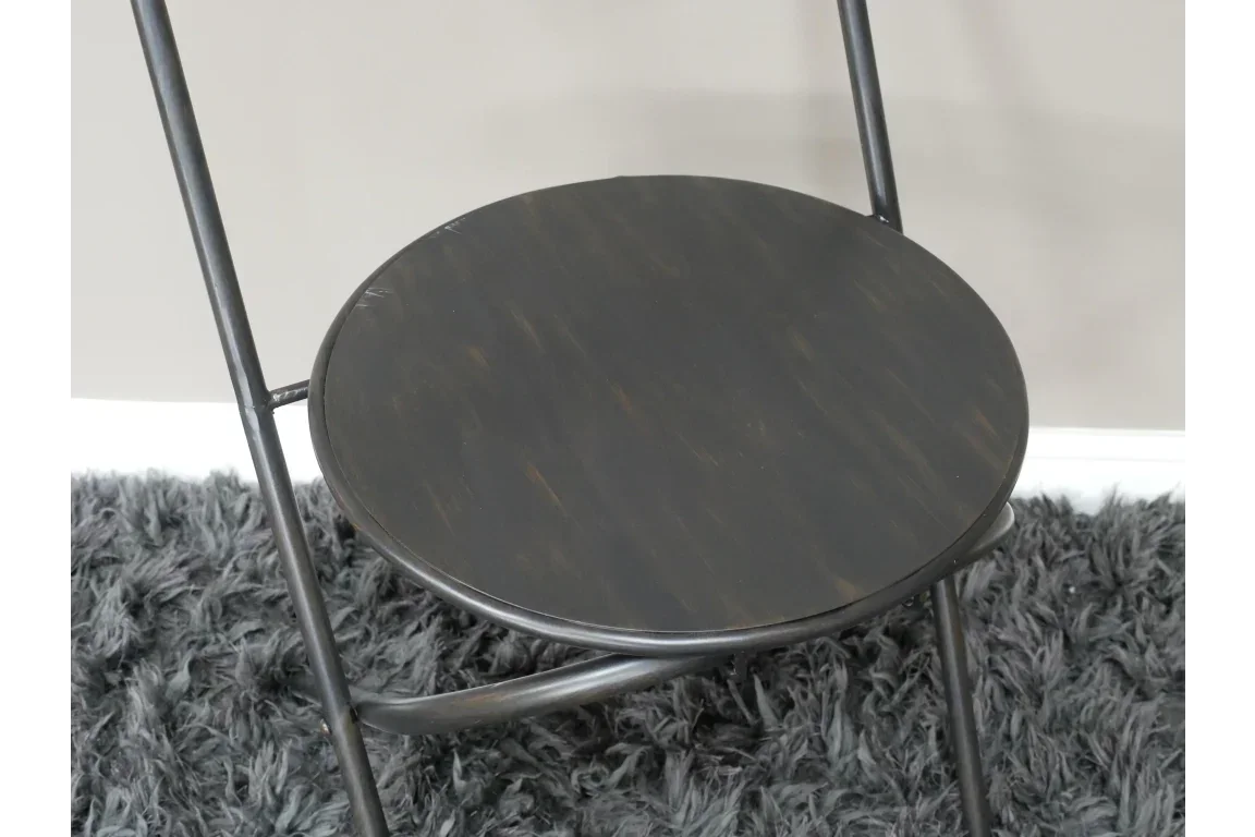 Black wooden round seat folding chair on grey shaggy rug, close-up view