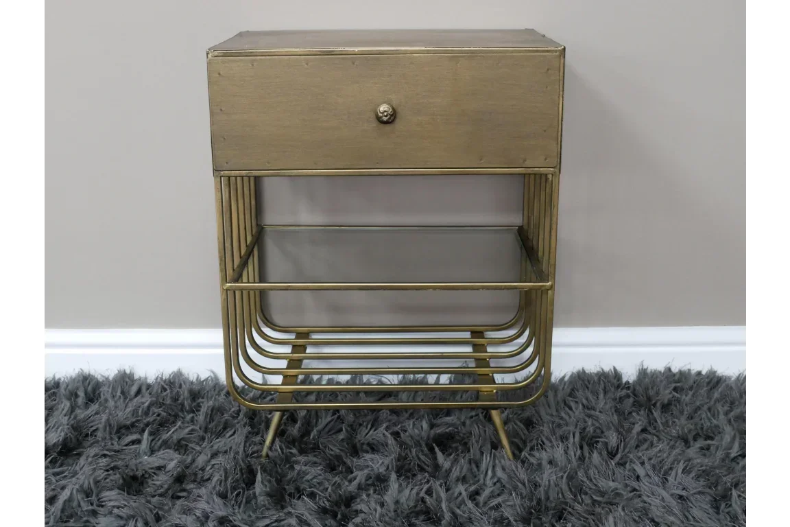 Gold metal bedside table with single drawer and glass shelf on grey shag rug