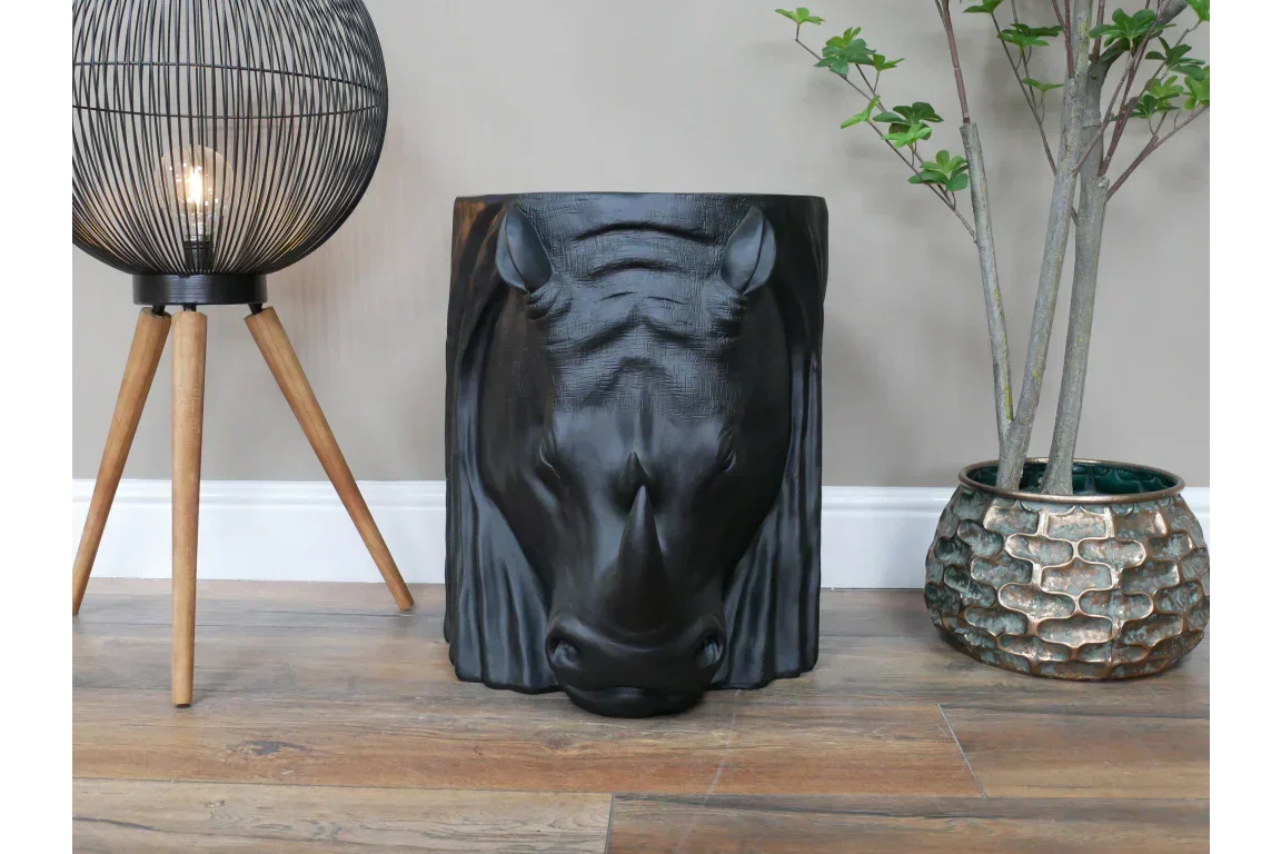 Black horse head accent table with wood grain detail beside lamp and plant pot on hardwood floor