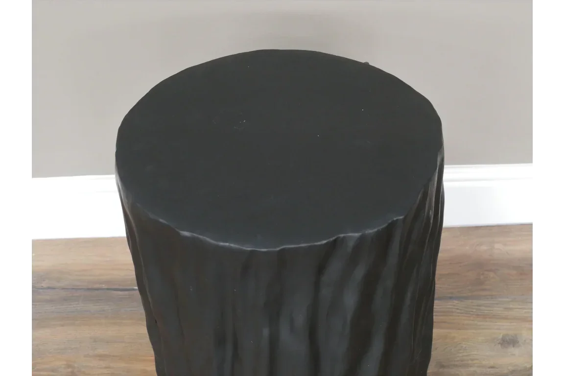 Black stump side table with textured finish on wooden floor