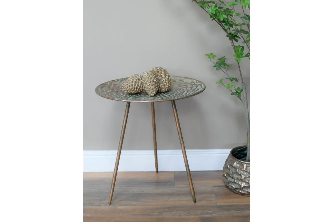 Round metal accent table with tripod legs and decorative gold pinecones
