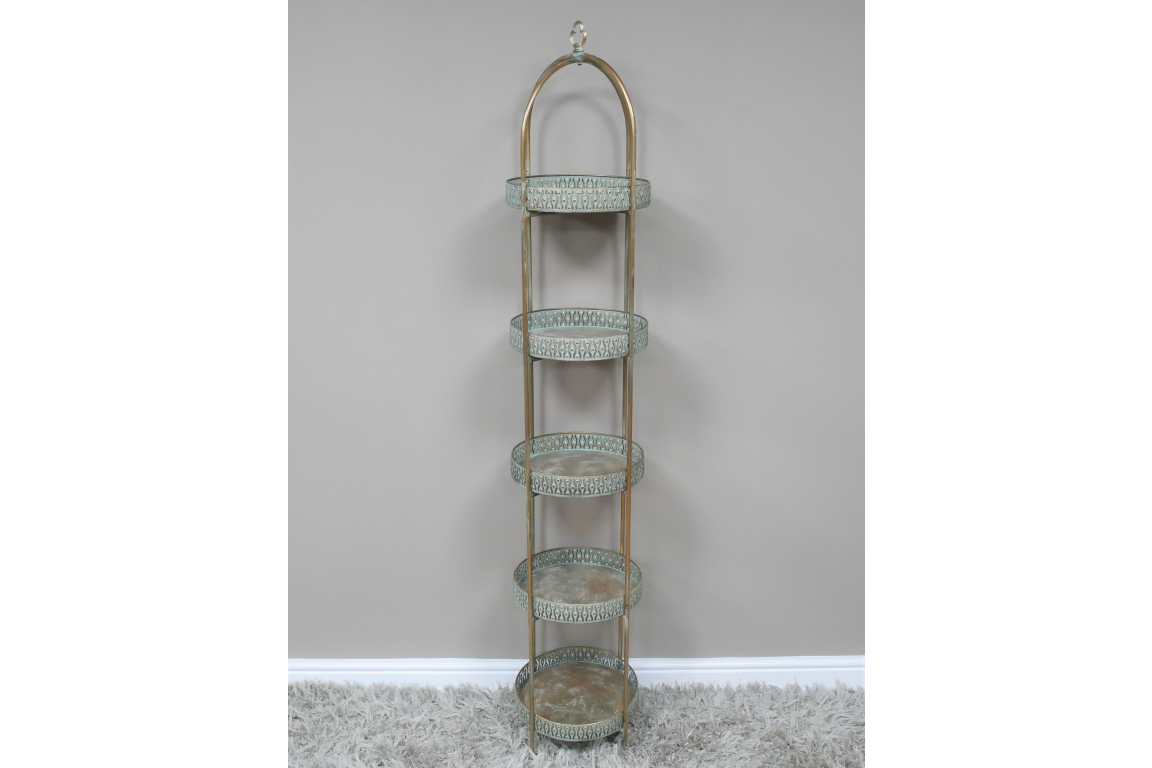 Tall Moroccan style 5 tier shelves with round blue-green metal trays and gold frame, standing on grey carpet by beige wall.
