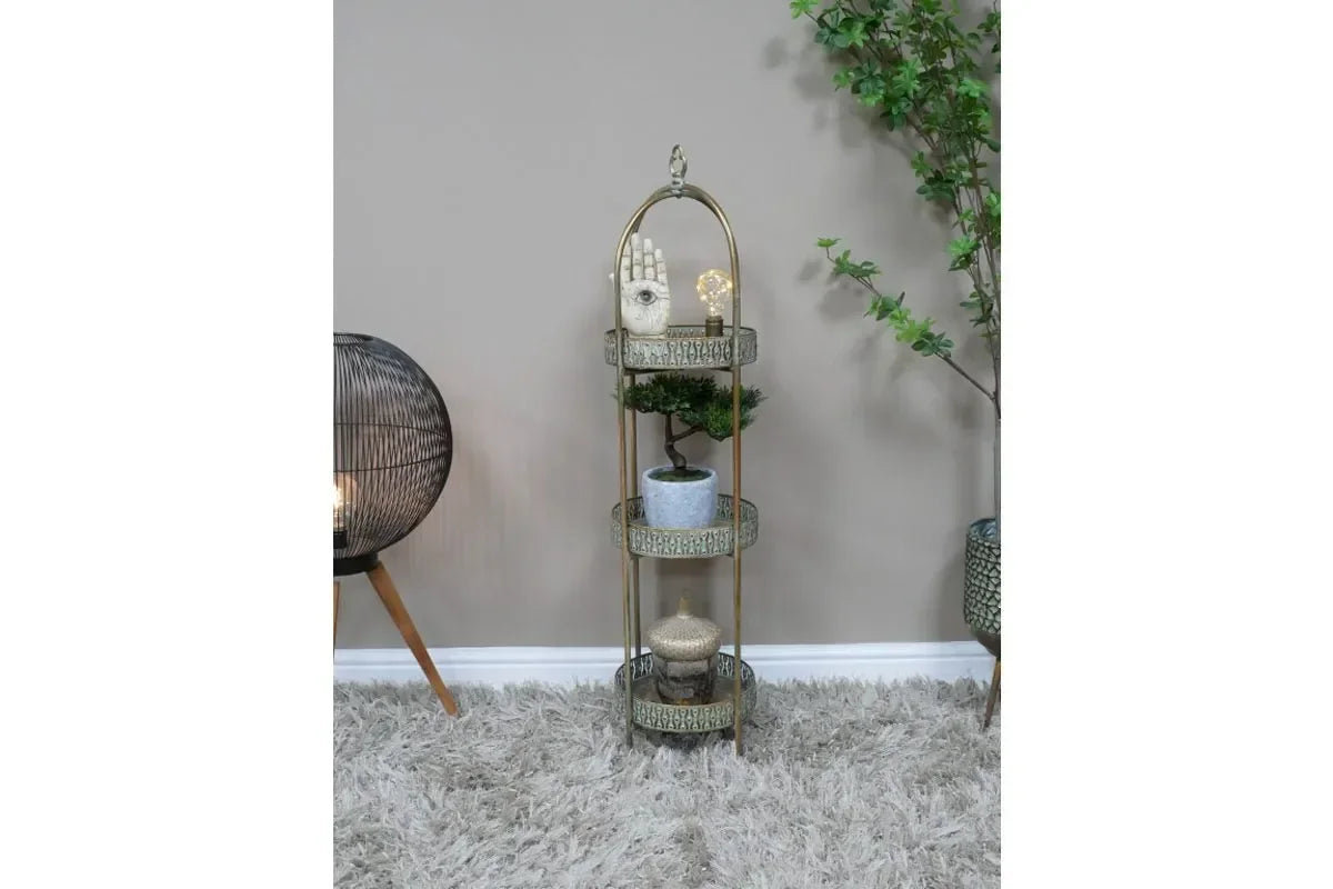 Three tier gold metal display stand with decorative items and plants in living room