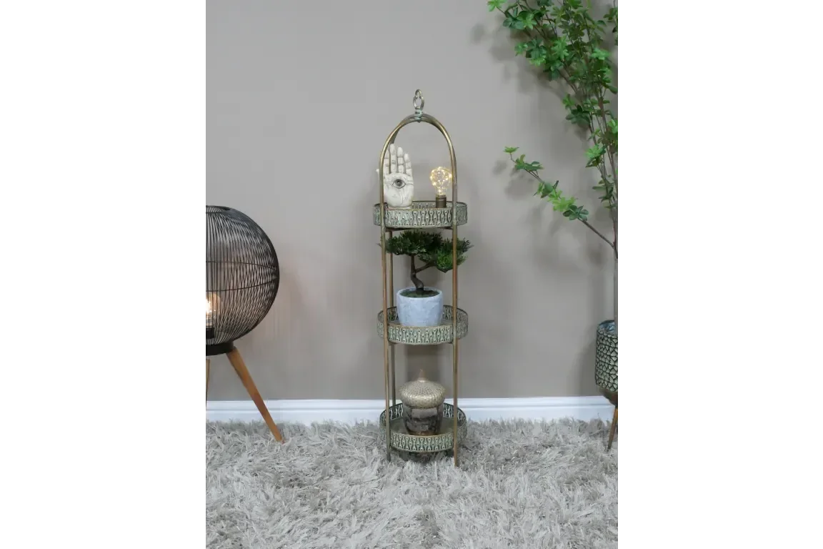 Gold metal three tier display stand with decorative trays and decor in living room corner