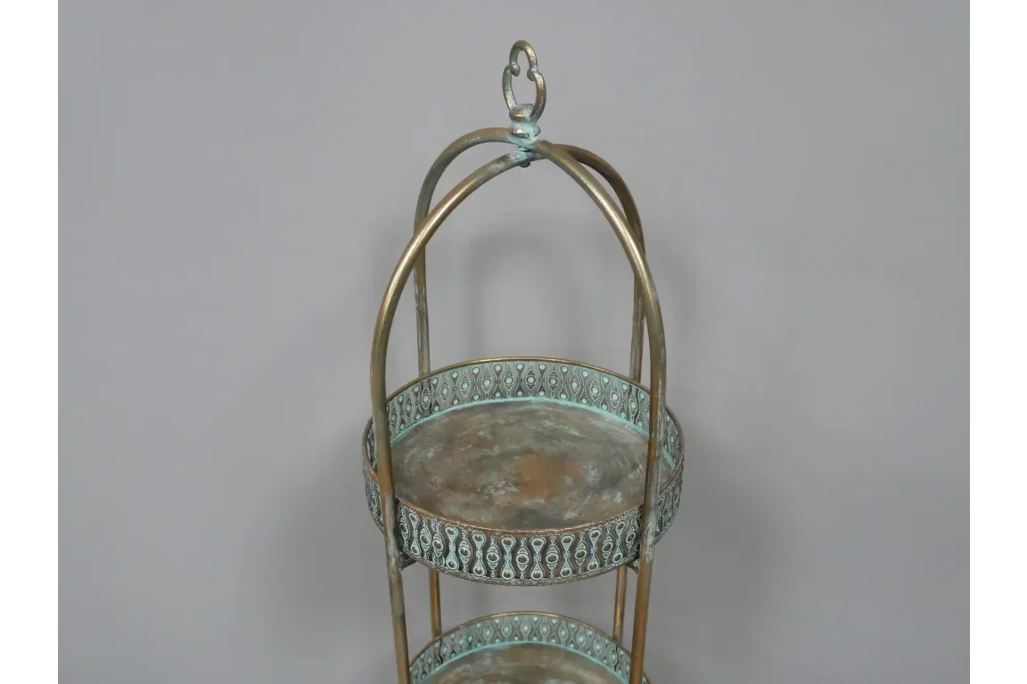 antique metal two tier tray with ornate pattern and arched brass handles