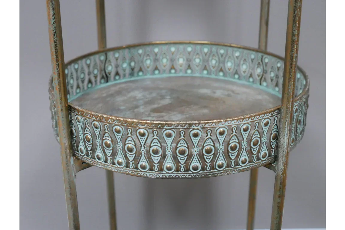 Round metal side table with ornate teal and brass detailing on raised edge