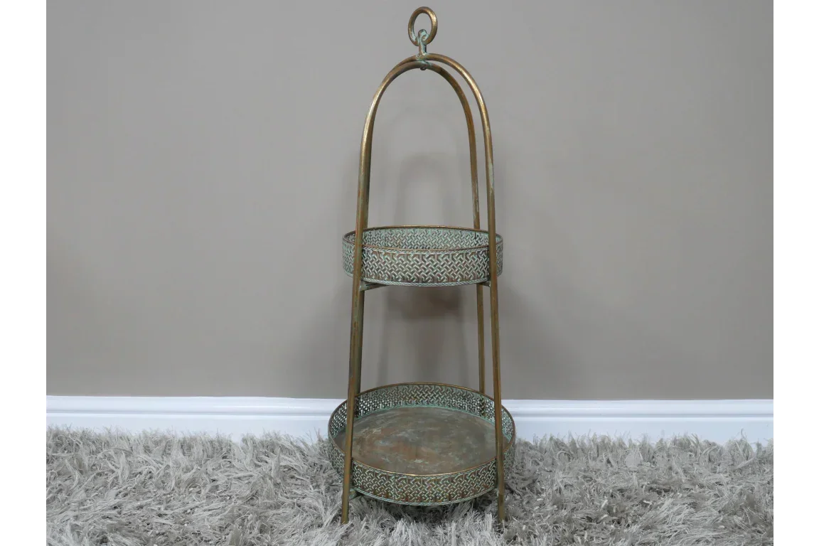 Two tier vintage brass side table with ornate trays on a shaggy rug
