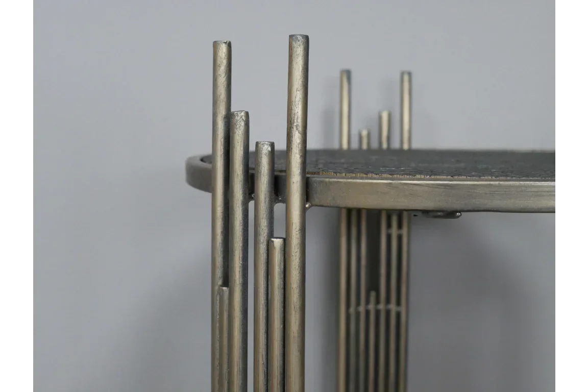 Close view of metal side table with cylindrical gold legs and round tabletop
