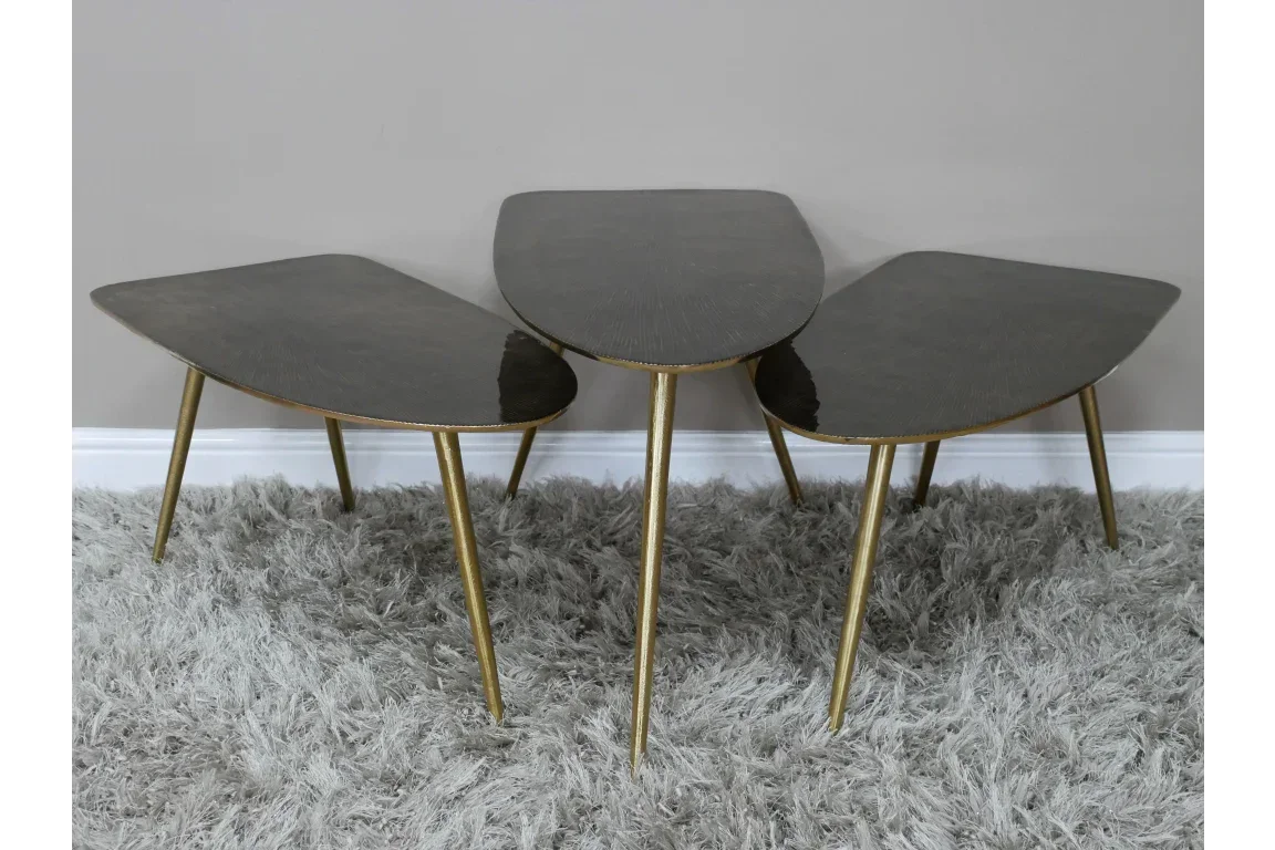 Set of three modern nesting coffee tables with gold legs on grey shaggy rug