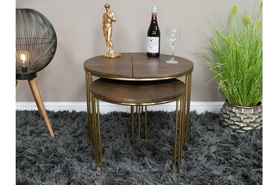 Gold and wood nested side tables with metal legs on grey rug, decorative items on top