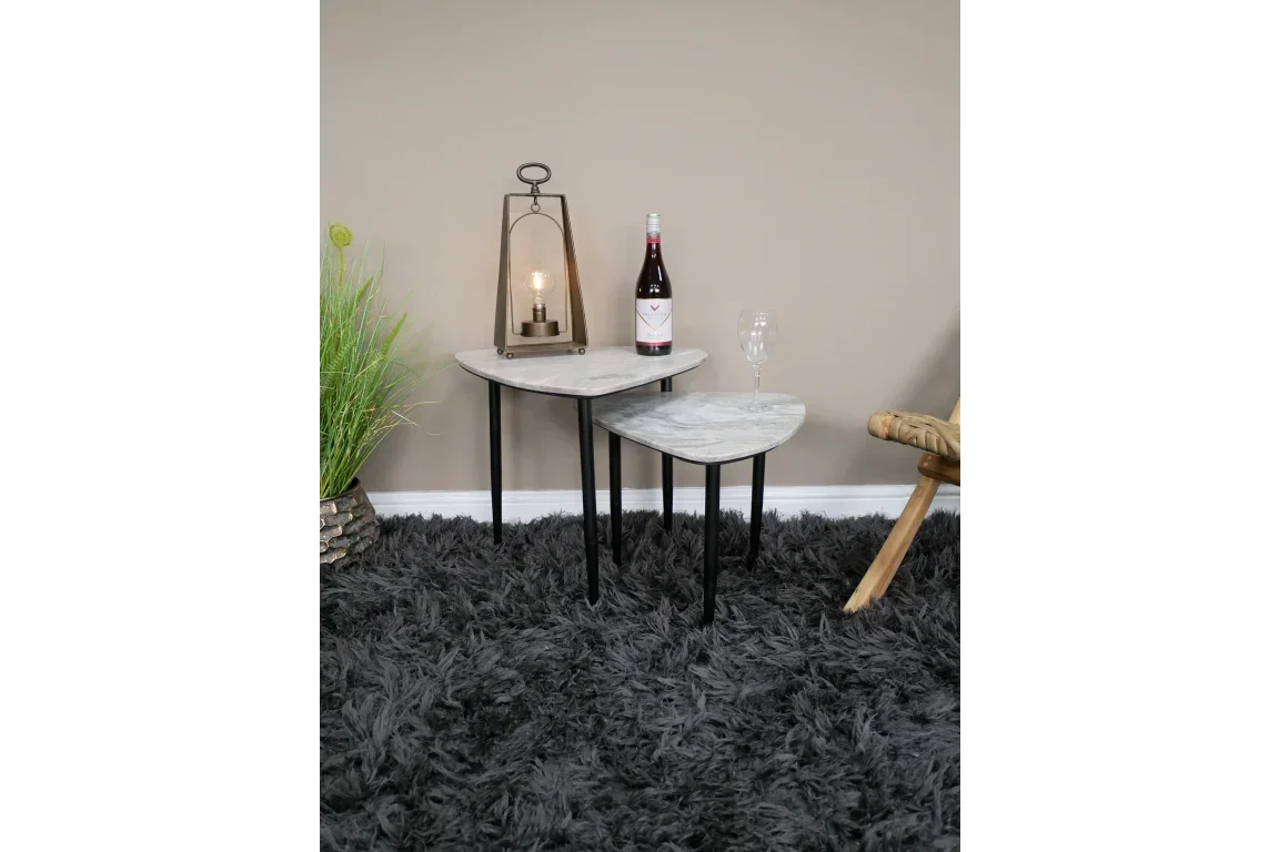 Set of two marble effect nesting tables with black legs on grey shaggy rug