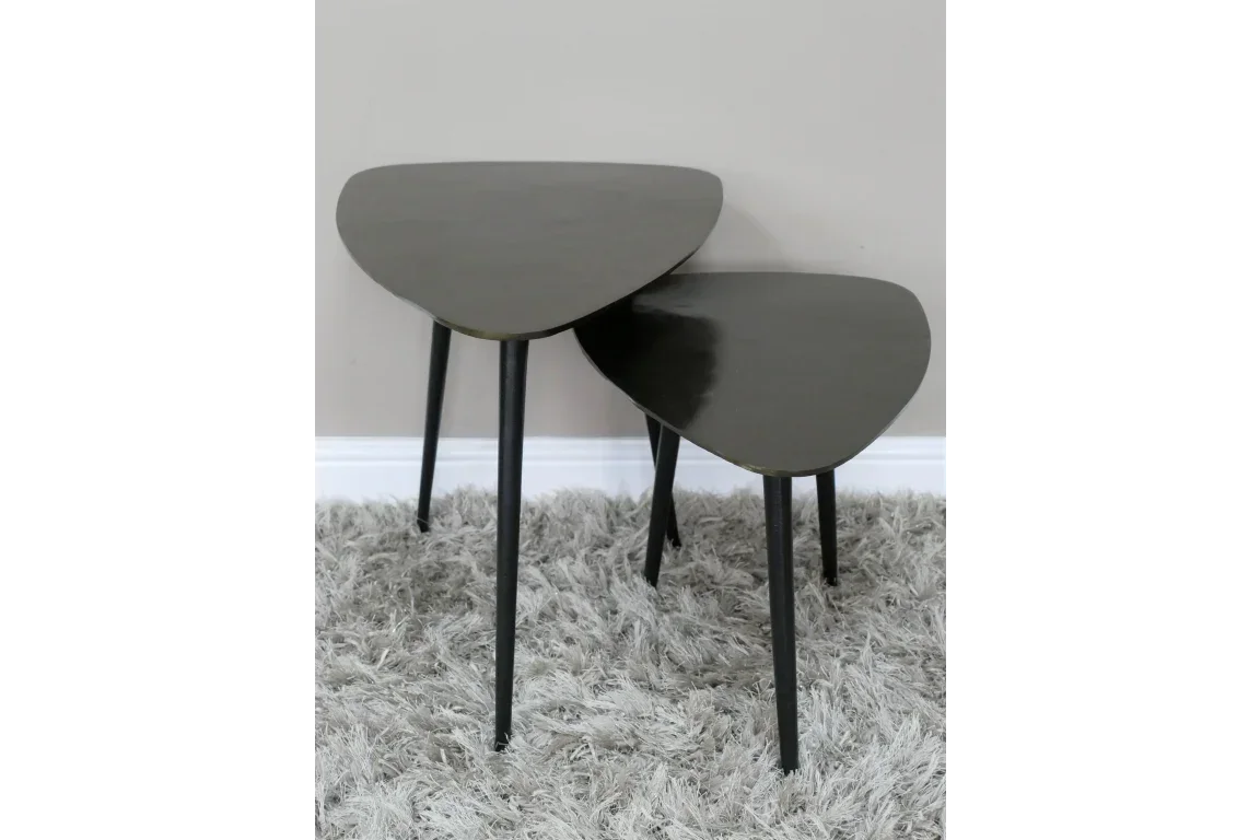 Set of two black nesting side tables with tapered legs on grey shaggy rug
