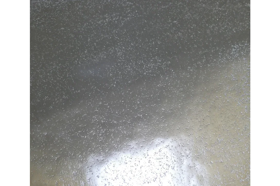 Closeup of clear textured glass table top surface with metallic finish