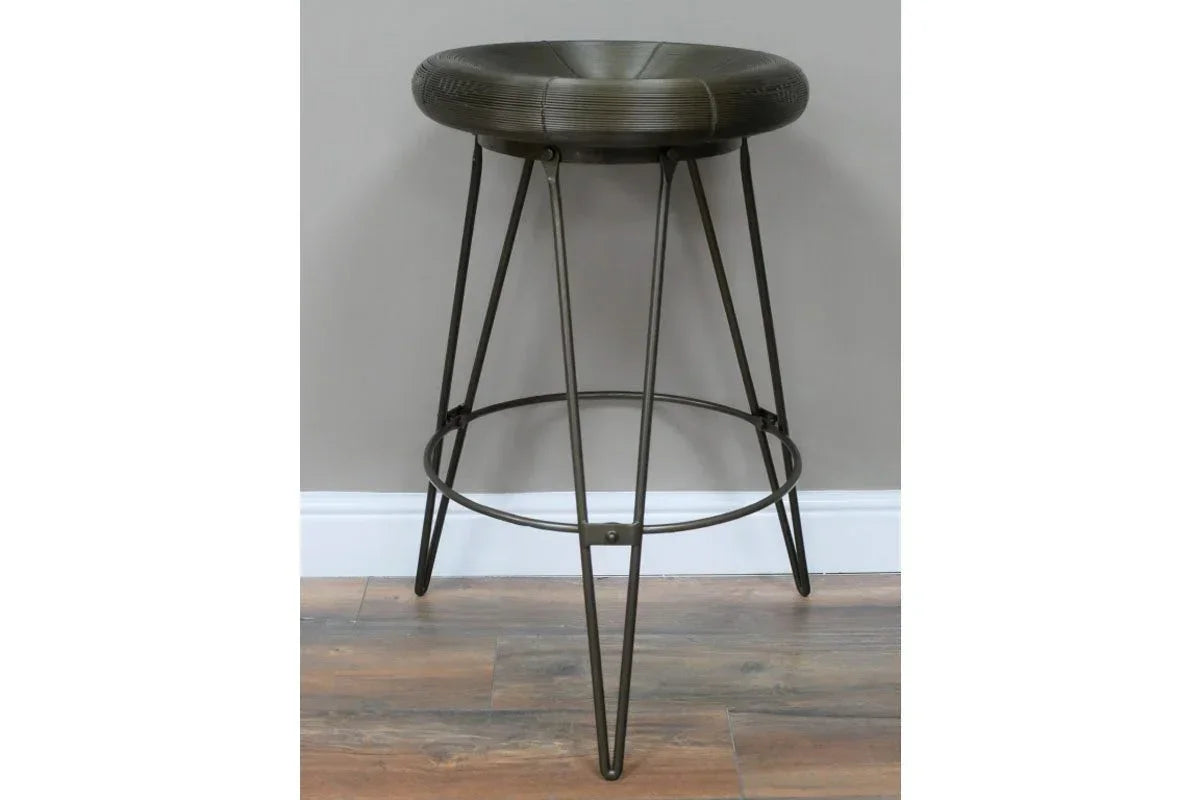 Industrial metal bar stool with round seat and hairpin legs on wood floor