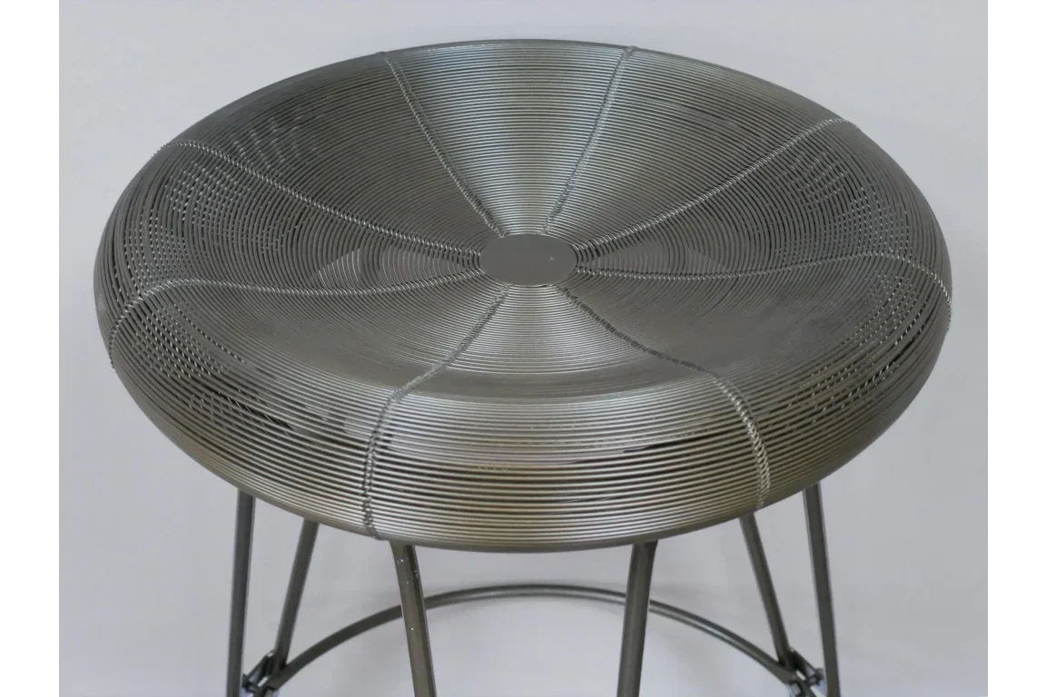 Round metal wire stool with open weave seat and black legs, close-up view