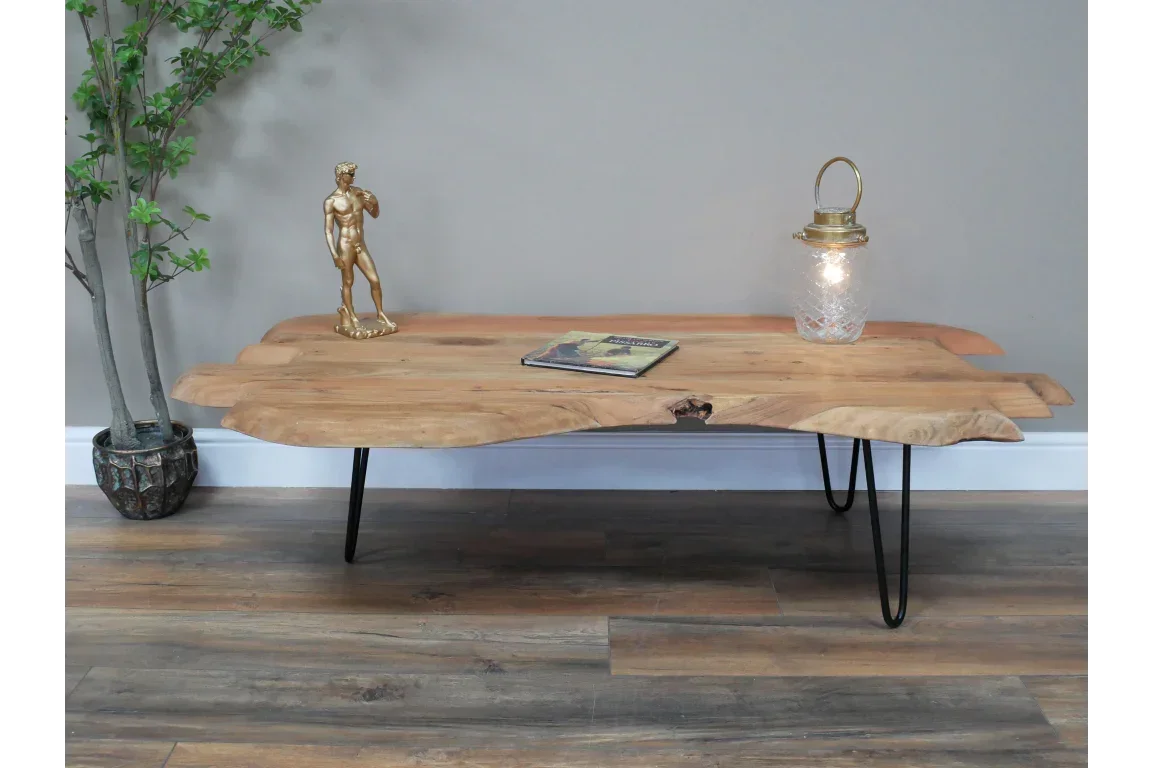 Live edge wooden coffee table with black metal hairpin legs, styled with decor items