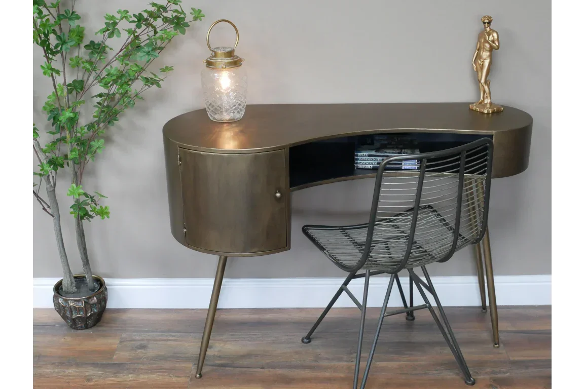 Brass metal console table with closed storage, wire chair, and decorative lamp in hallway