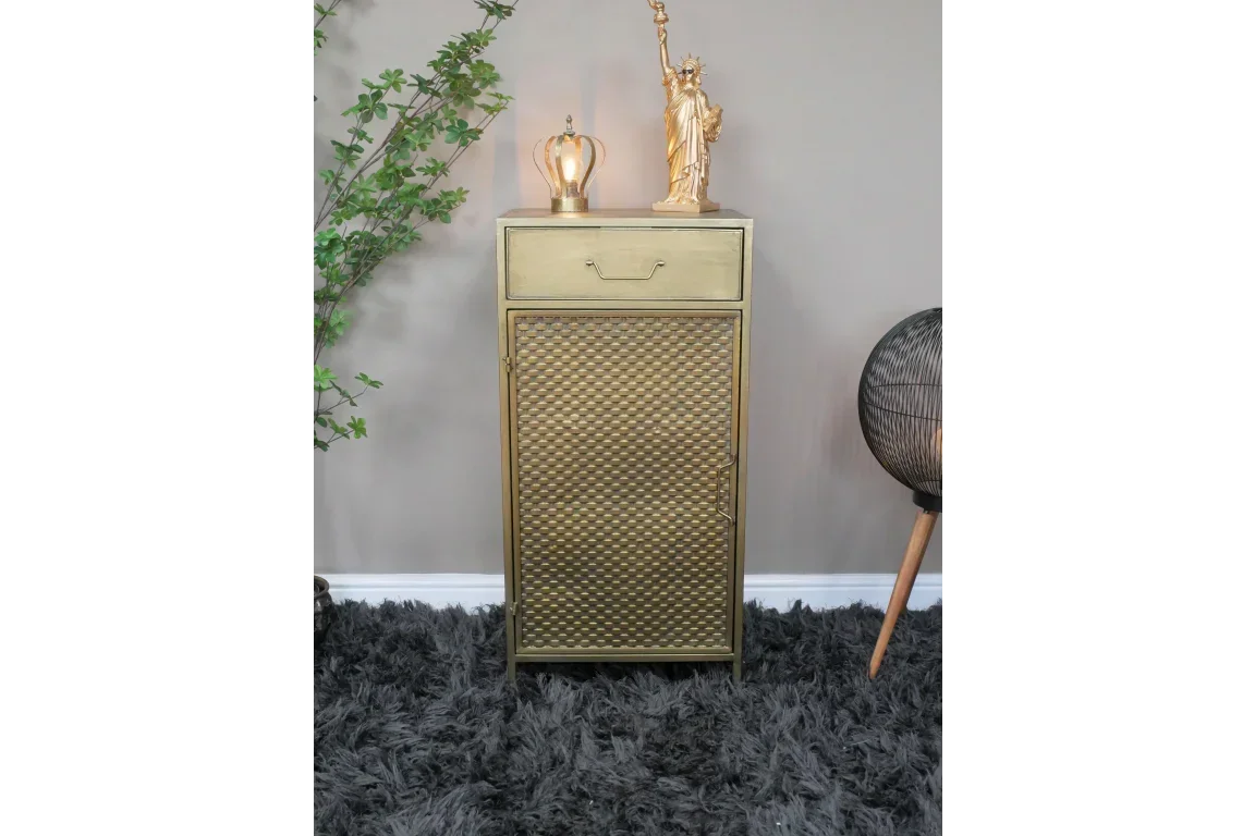 Gold metal cabinet with textured door and drawer, styled with gold ornaments on top
