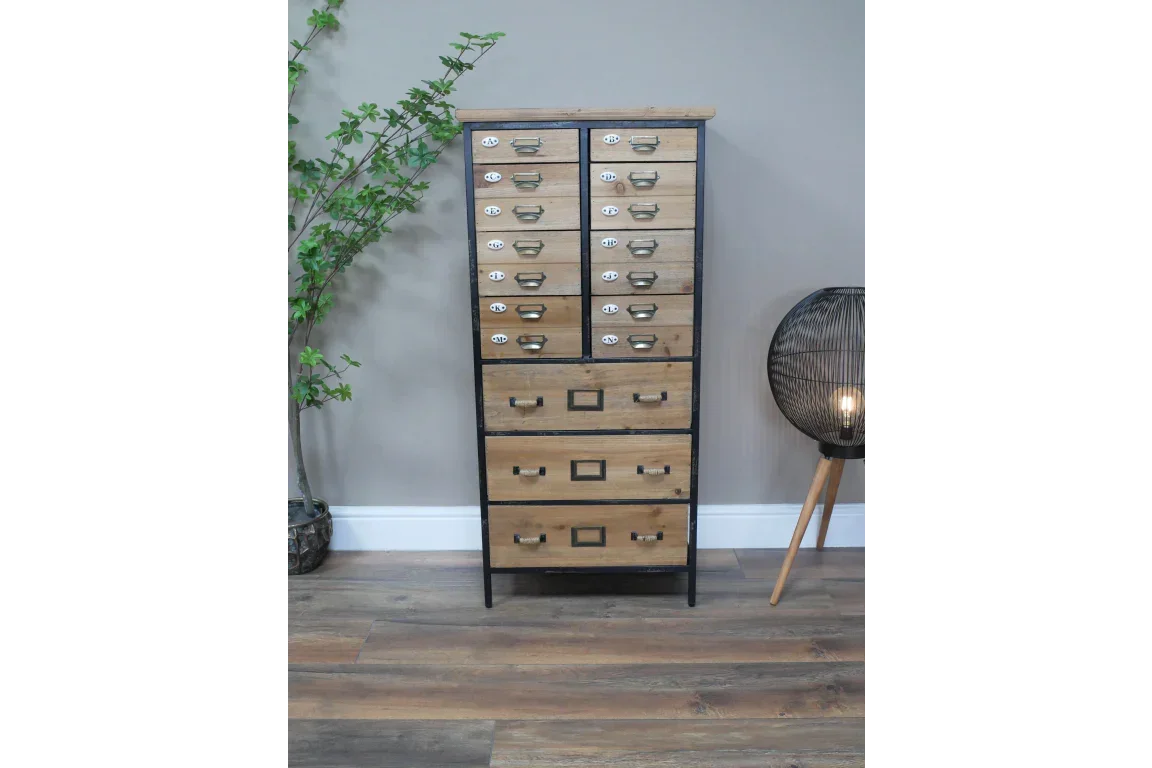 Industrial wooden chest of drawers with metal frame and label handles, standing on wood floor