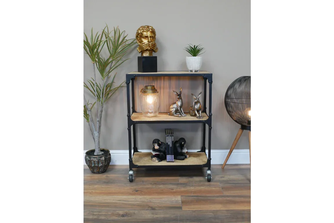 Industrial style shelving unit with wood shelves, decorative ornaments, and caster wheels