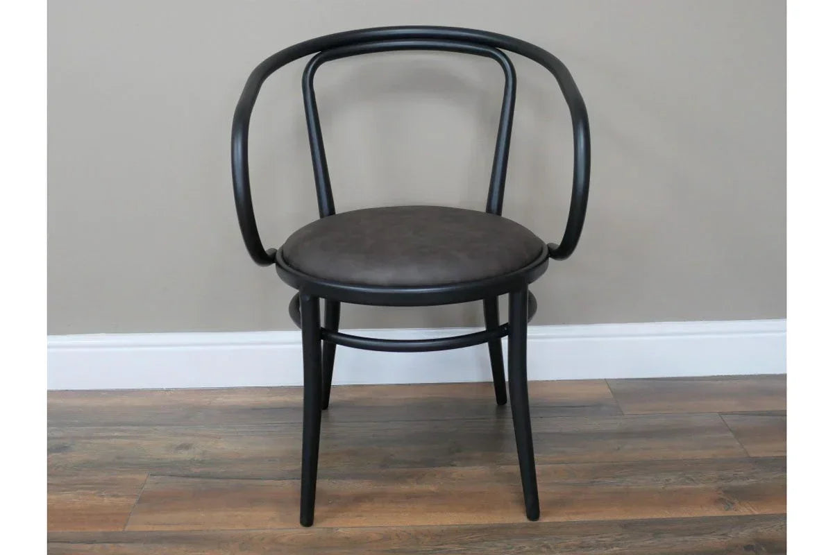 Black bentwood dining chair with rounded backrest and padded seat on wooden floor