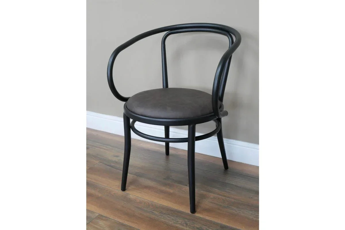 Black bentwood dining chair with curved back and round grey seat on wood floor