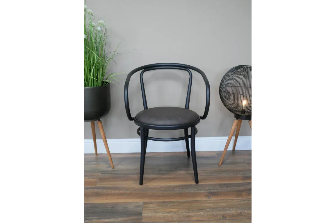 Black bentwood dining chair with curved backrest and round seat on wood floor