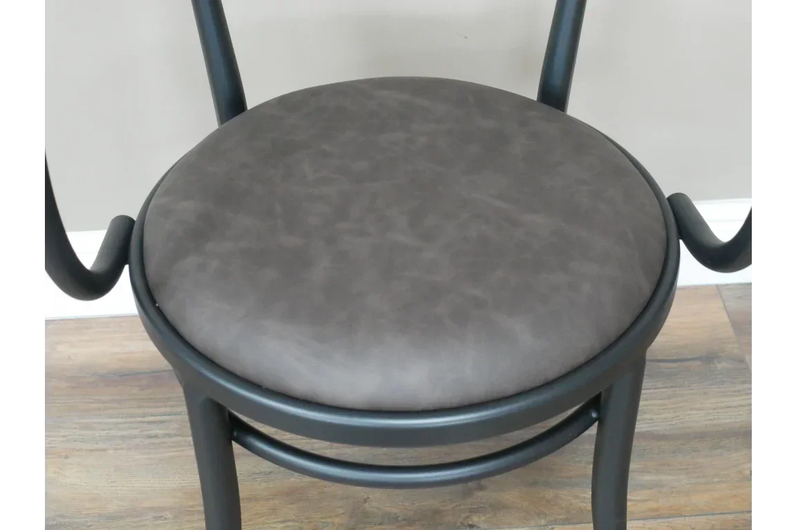 Close-up of dining chair with dark wood frame and round cushioned brown seat