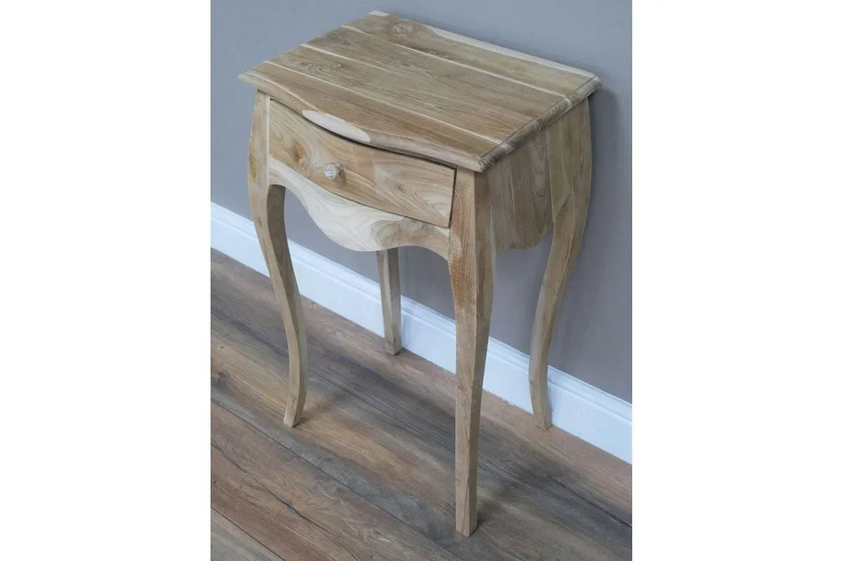 Natural wood bedside table with curved legs and single drawer against grey wall