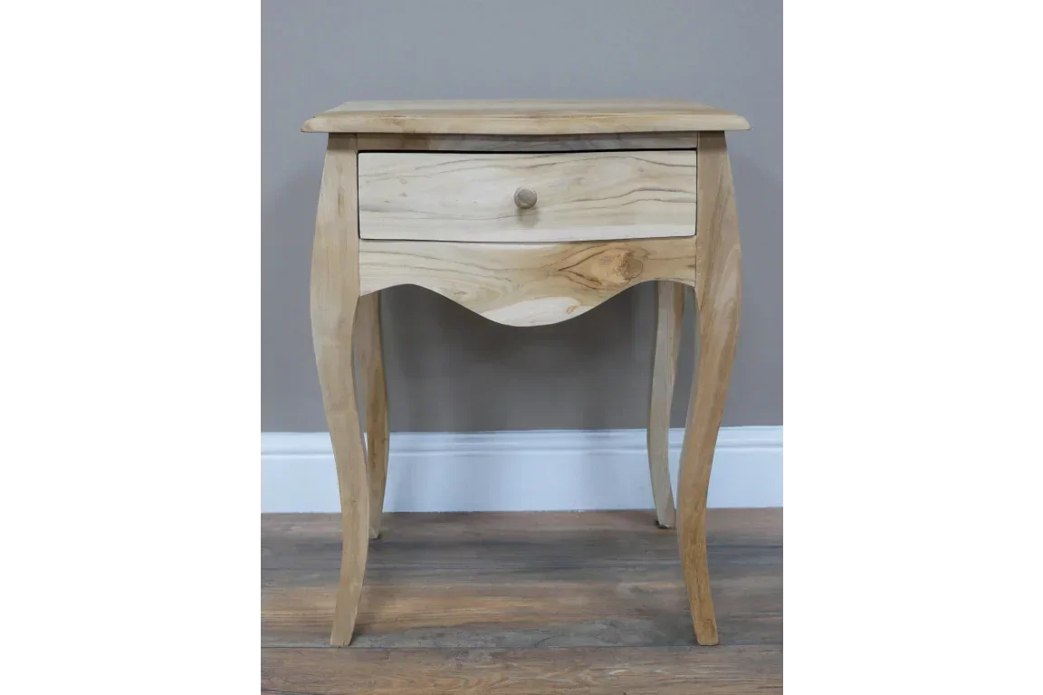 Natural wood bedside table with curved legs and single drawer on hardwood floor
