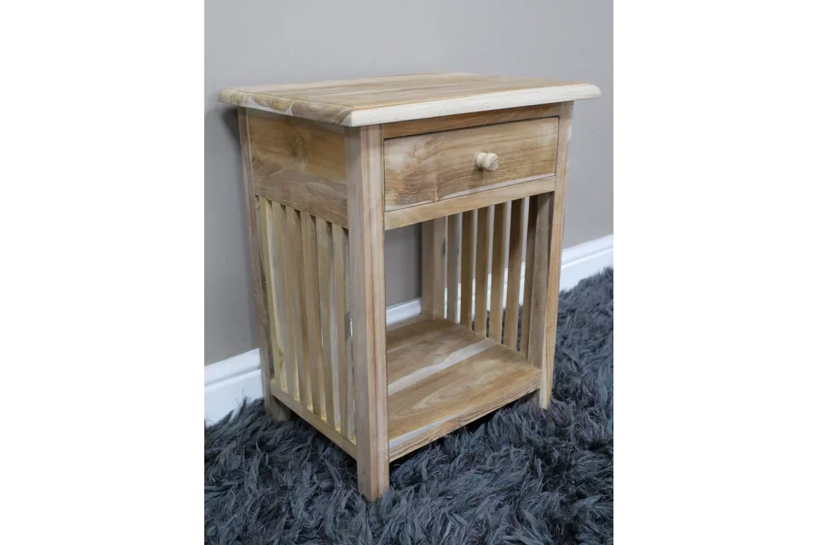 Light wood bedside table with slatted sides, single drawer and open shelf on grey rug
