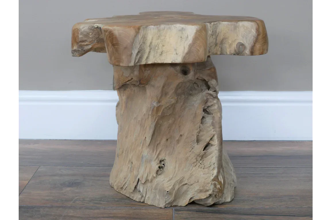 Natural wood side table with rustic finish on wooden flooring against a grey wall