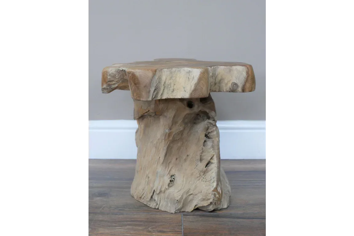 Solid wood stump side table with natural grain and rustic finish on wooden floor