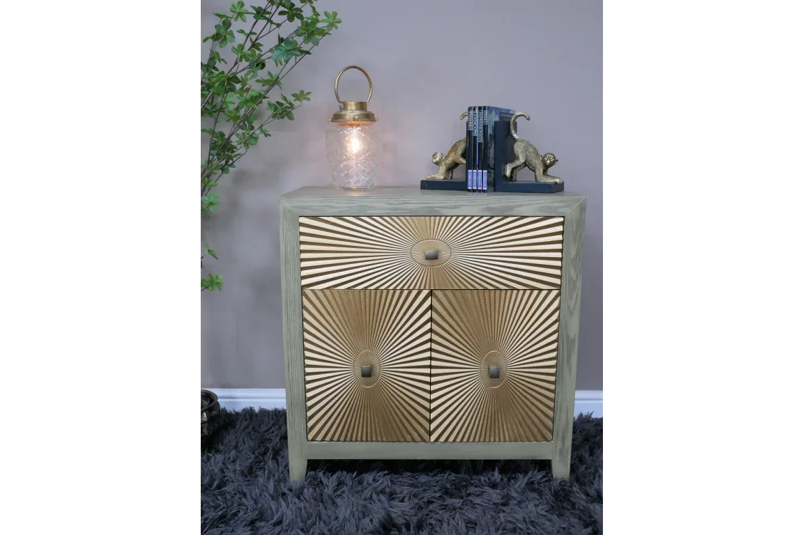 Gold geometric front chest of drawers with decorative books and lamp on top