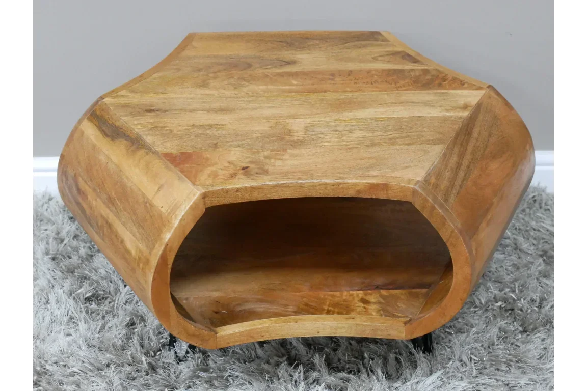 Hexagonal mango wood coffee table with open shelf on grey rug