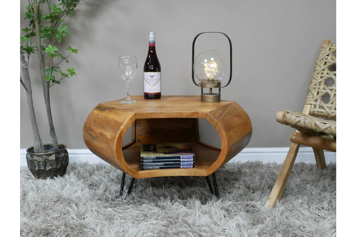Solid wood coffee table with open storage, black metal legs, books and decor on top