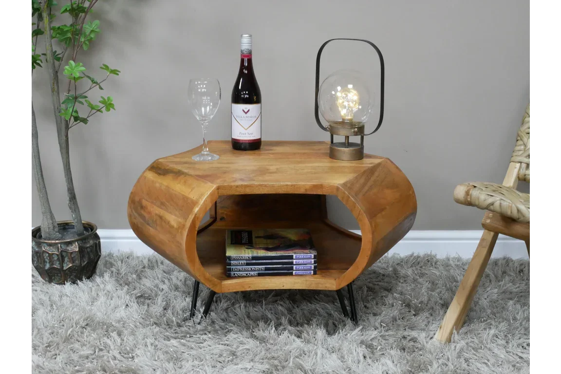 Hexagonal wooden coffee table with metal legs, open shelf, lamp and wine on top
