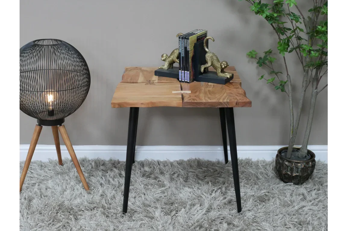 Solid wood side table with black metal legs, books and gold monkey bookends on top