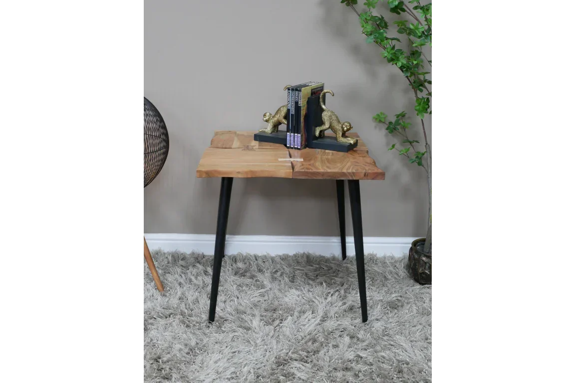 Live edge wooden side table with black metal legs and decorative bookends in modern room
