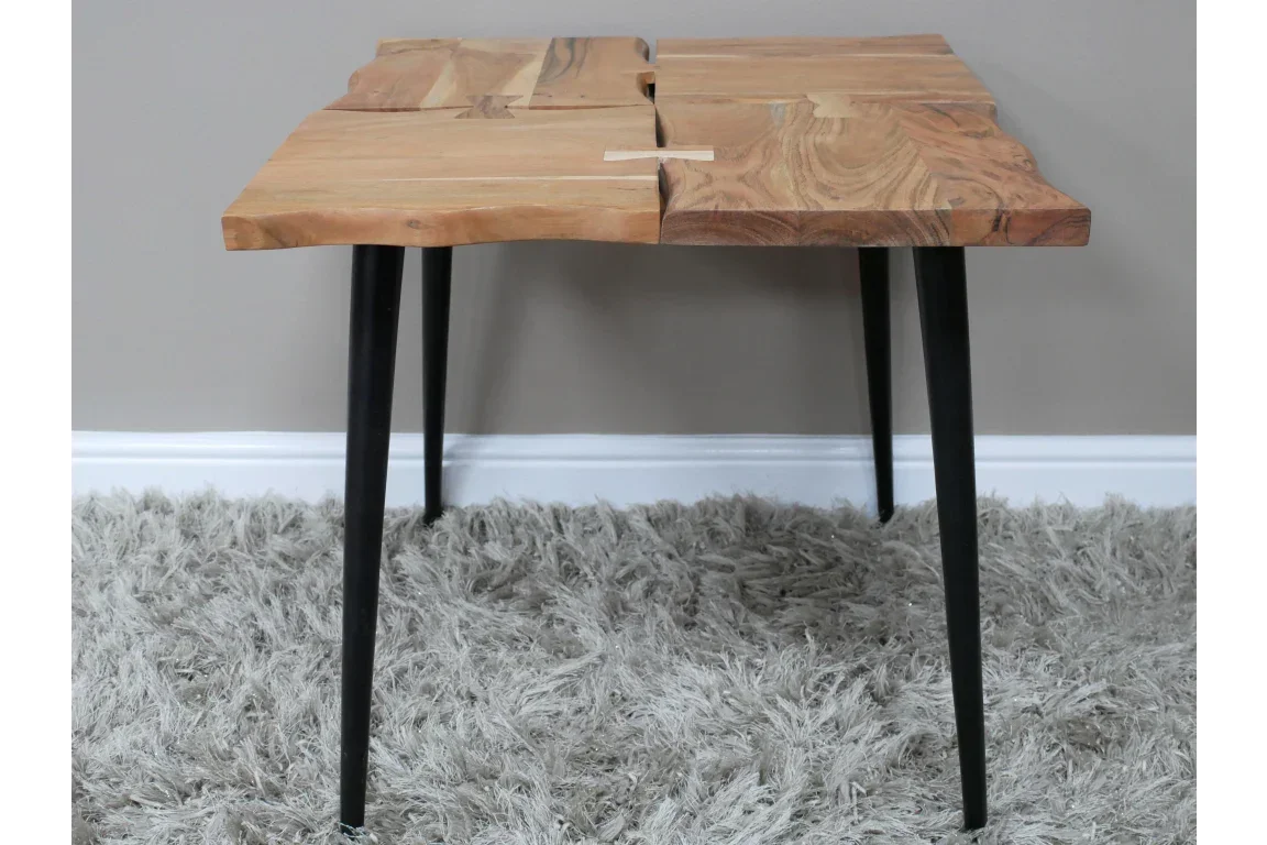 Live edge wooden coffee table with black metal legs on grey shaggy rug