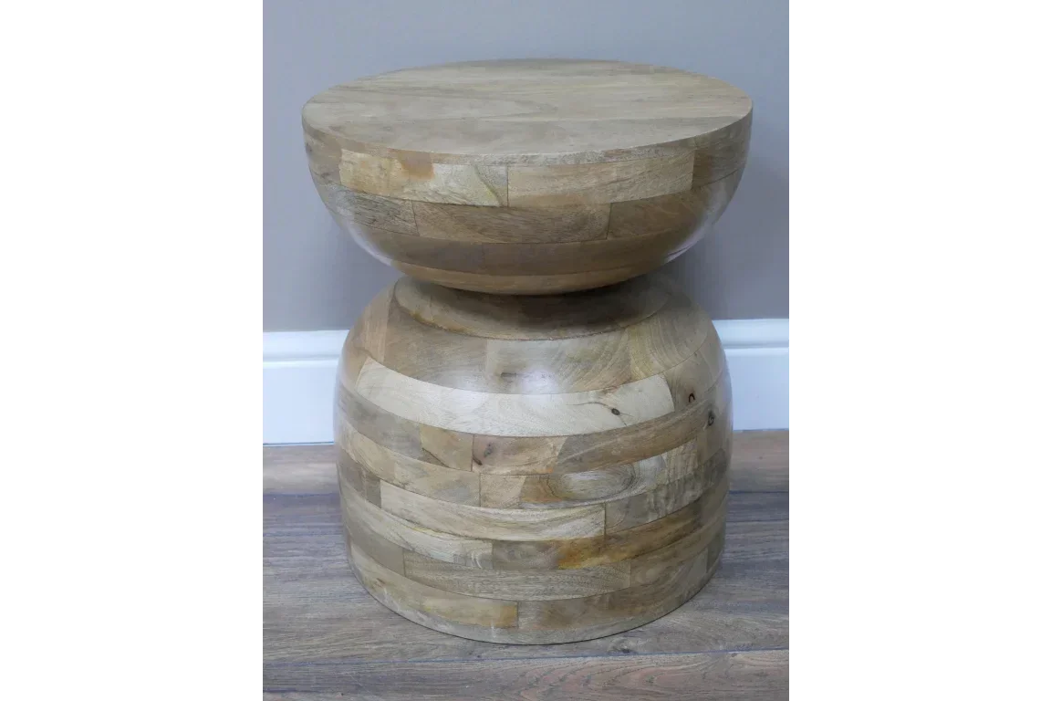 Round mango wood side table with natural grain finish on wooden floor