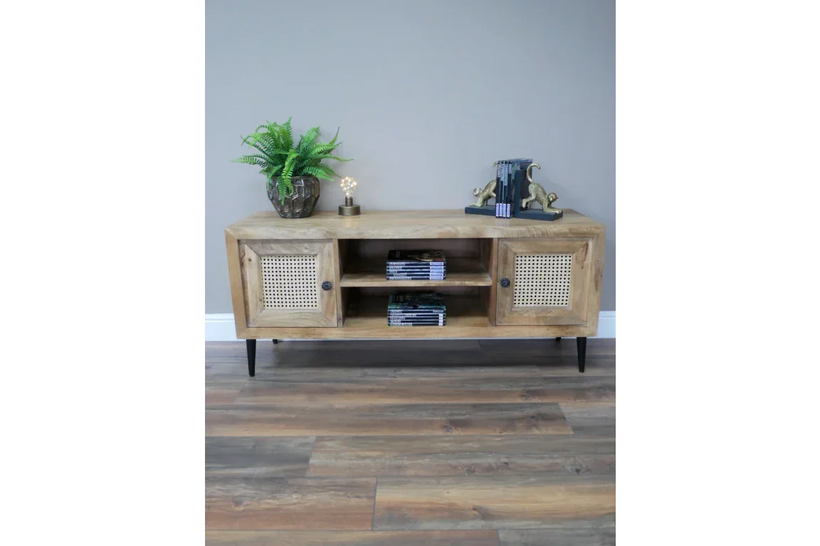 Wooden TV unit with rattan doors, open shelving and black legs on wooden floor